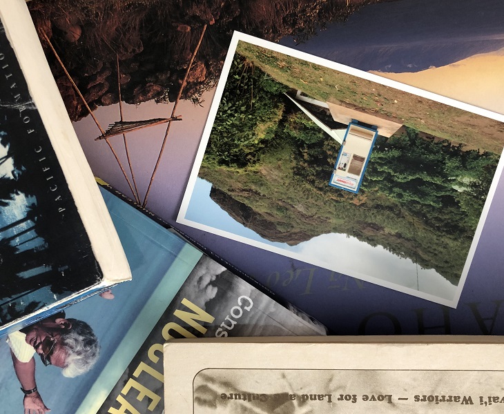 postcards and books over image of mountainous landscape sunset